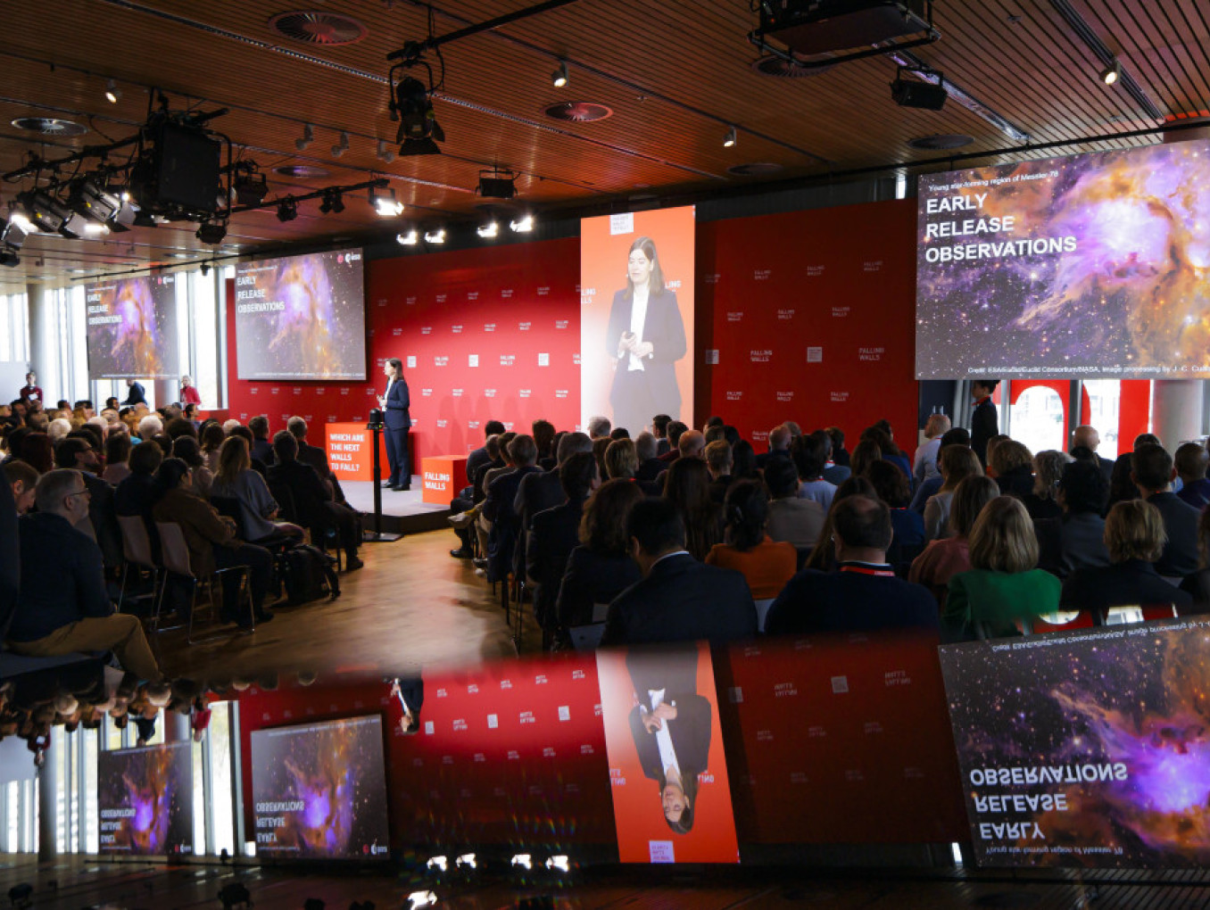 Event room, spotlight on the stage, a lot of people listening