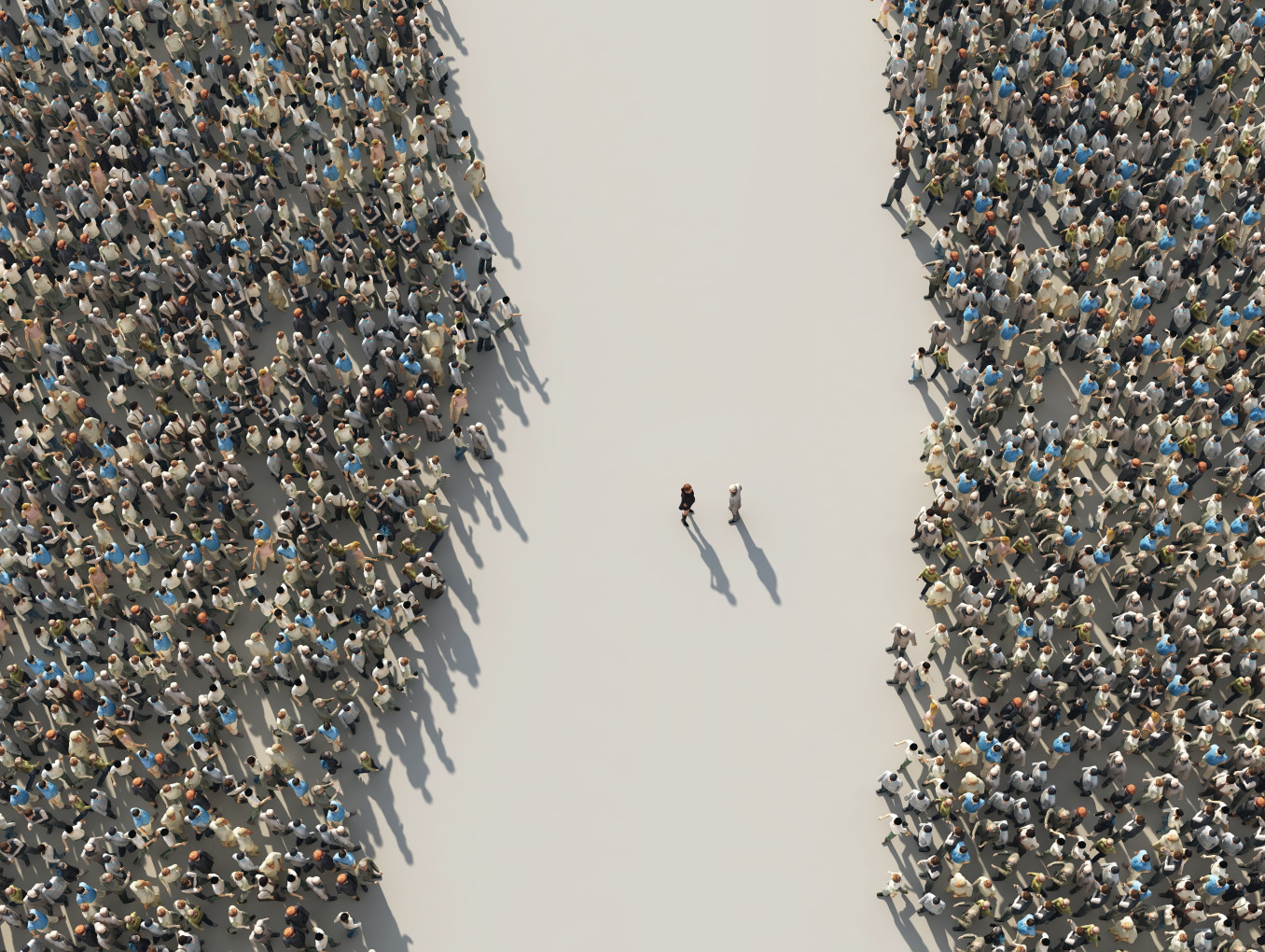 An image from above of two groups of people separated by n empty street, with two people in the middle