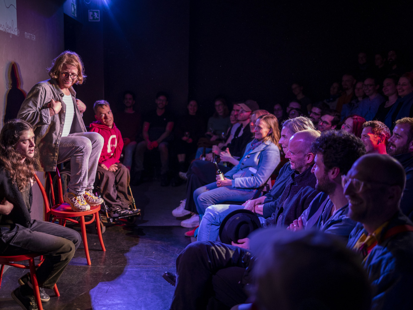 People in a room watching performers