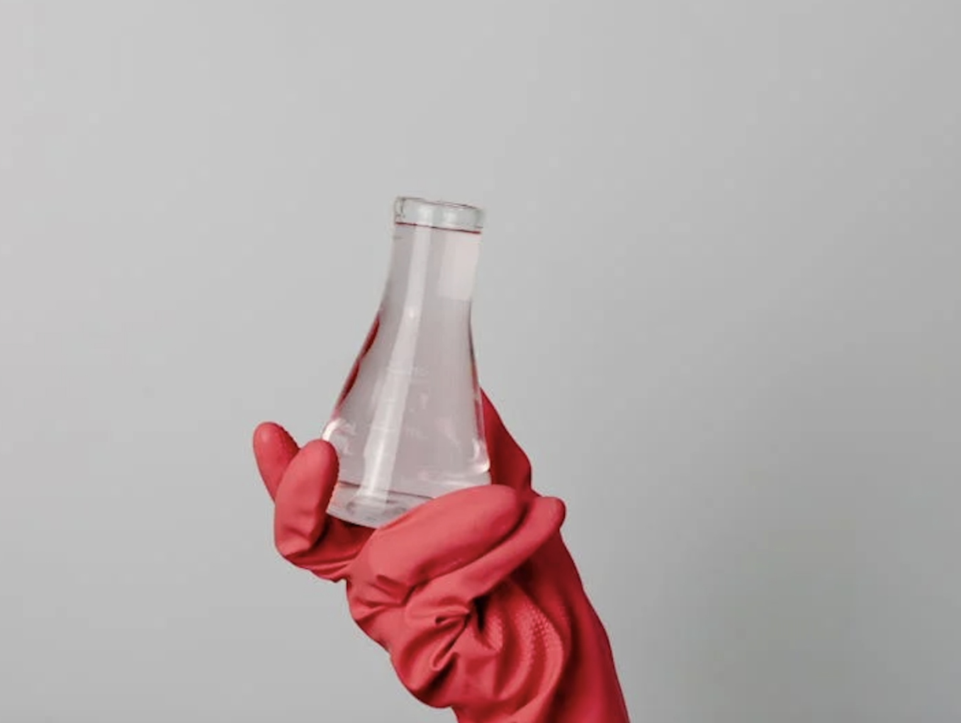 photograph of lab beaker being held by red glove