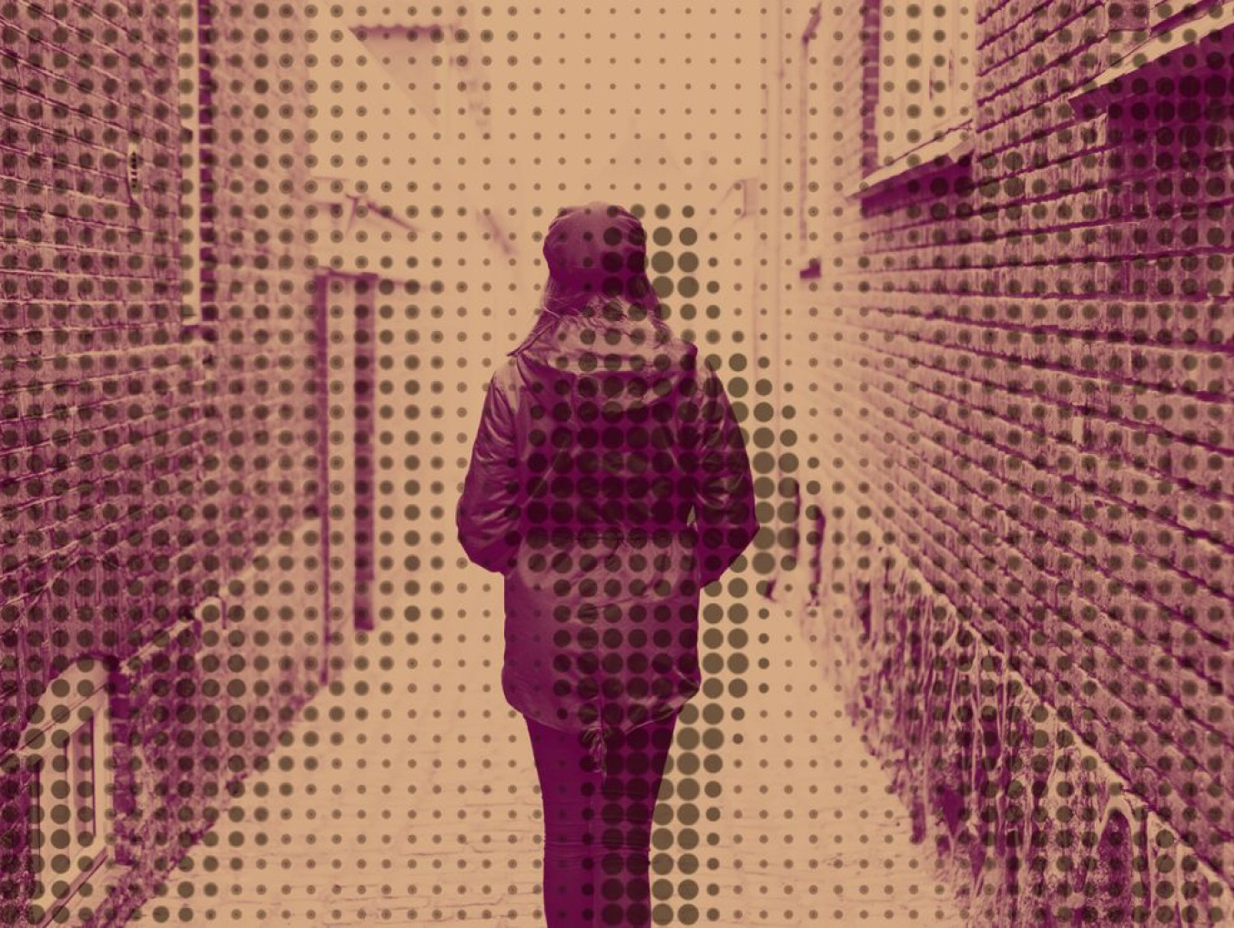 A woman is seen from behind as she walks down an alley.