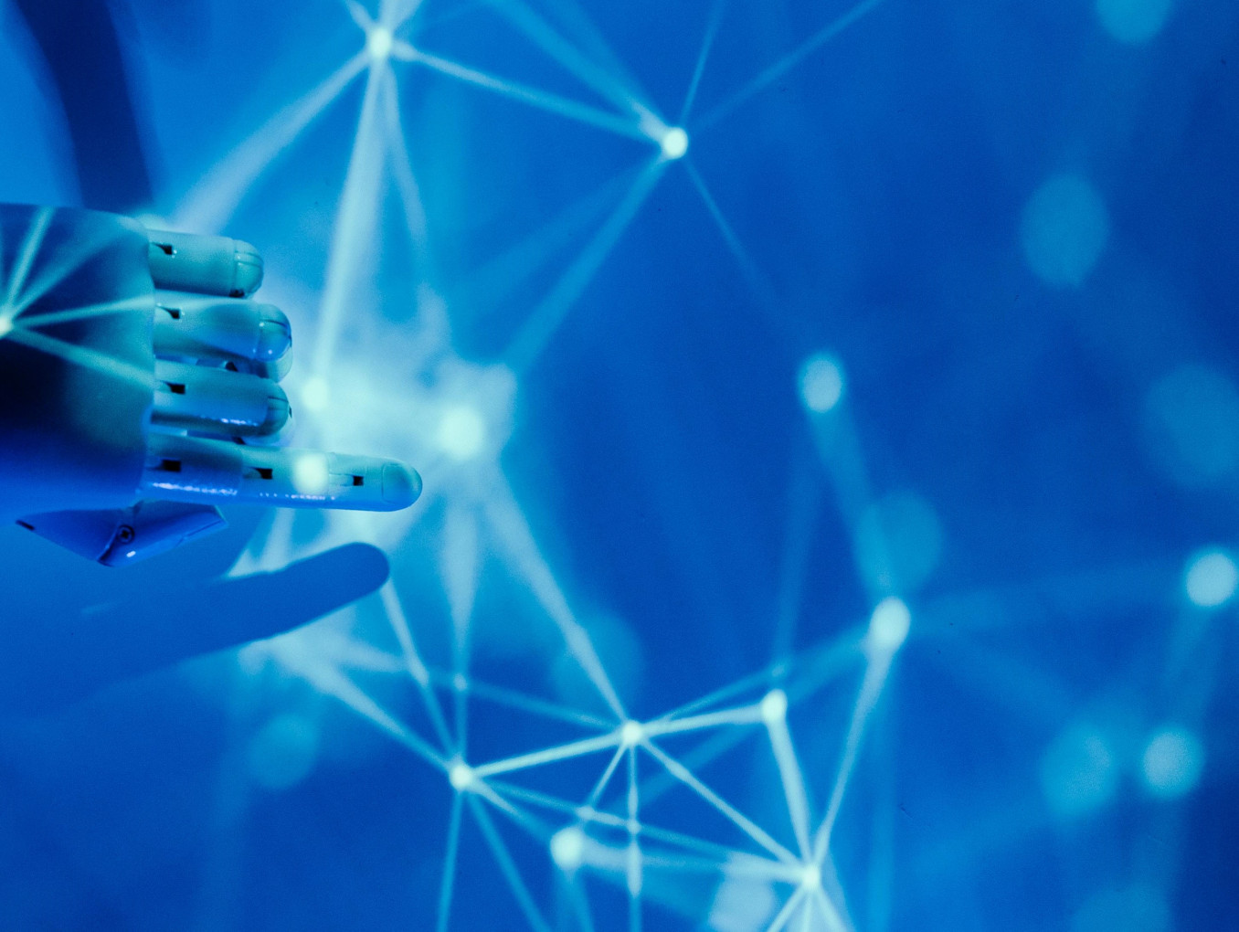Das Bild zeigt eine Roboterhand, die mit einem Netzwerk aus Lichtpunkten interagiert.