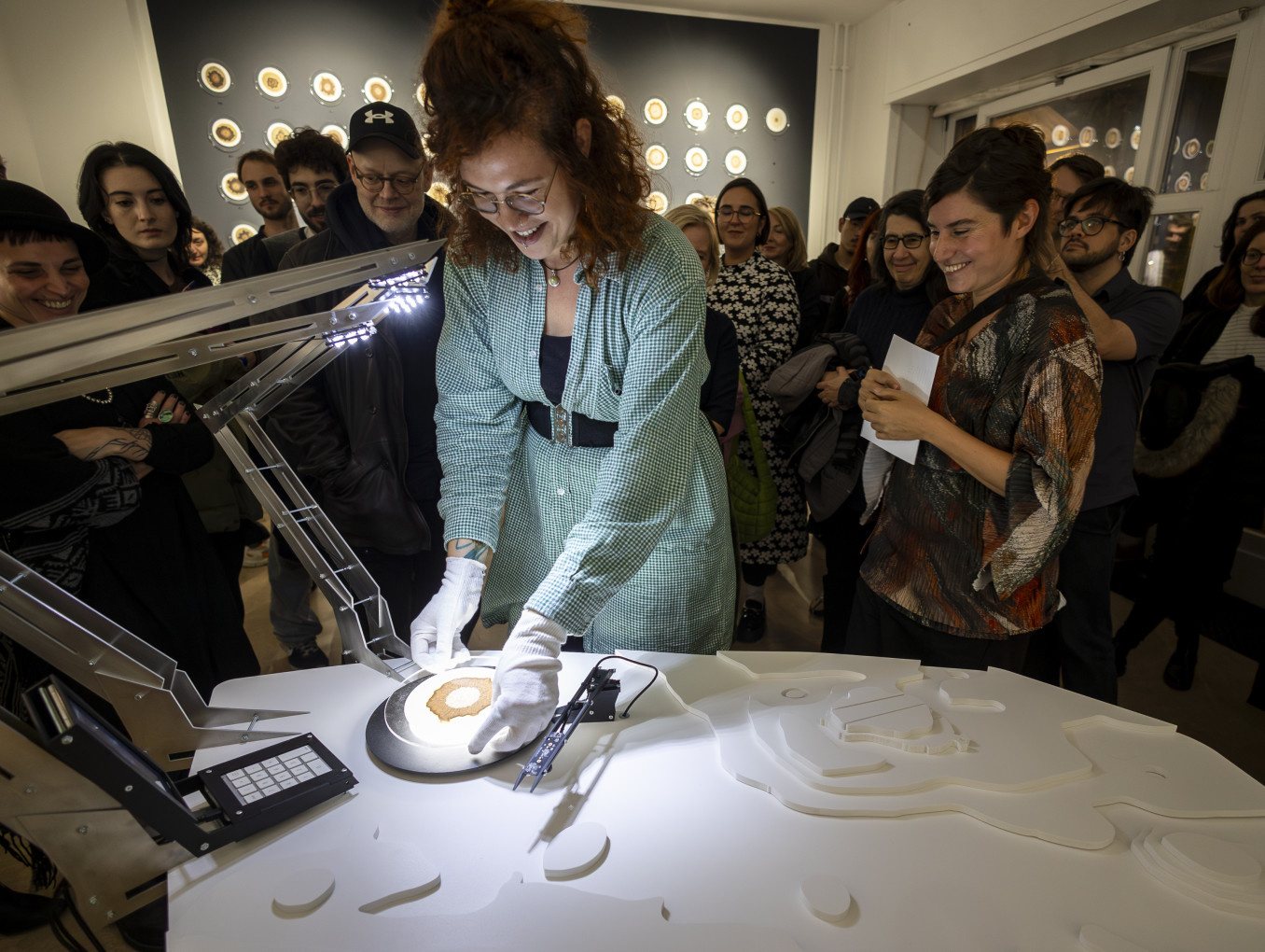 A scientists doing an experiment surrounded by a crowd.