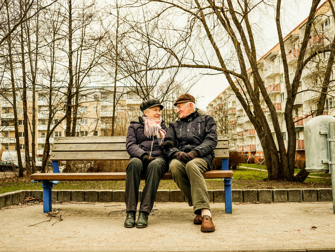 An elderly couple sits outside. 