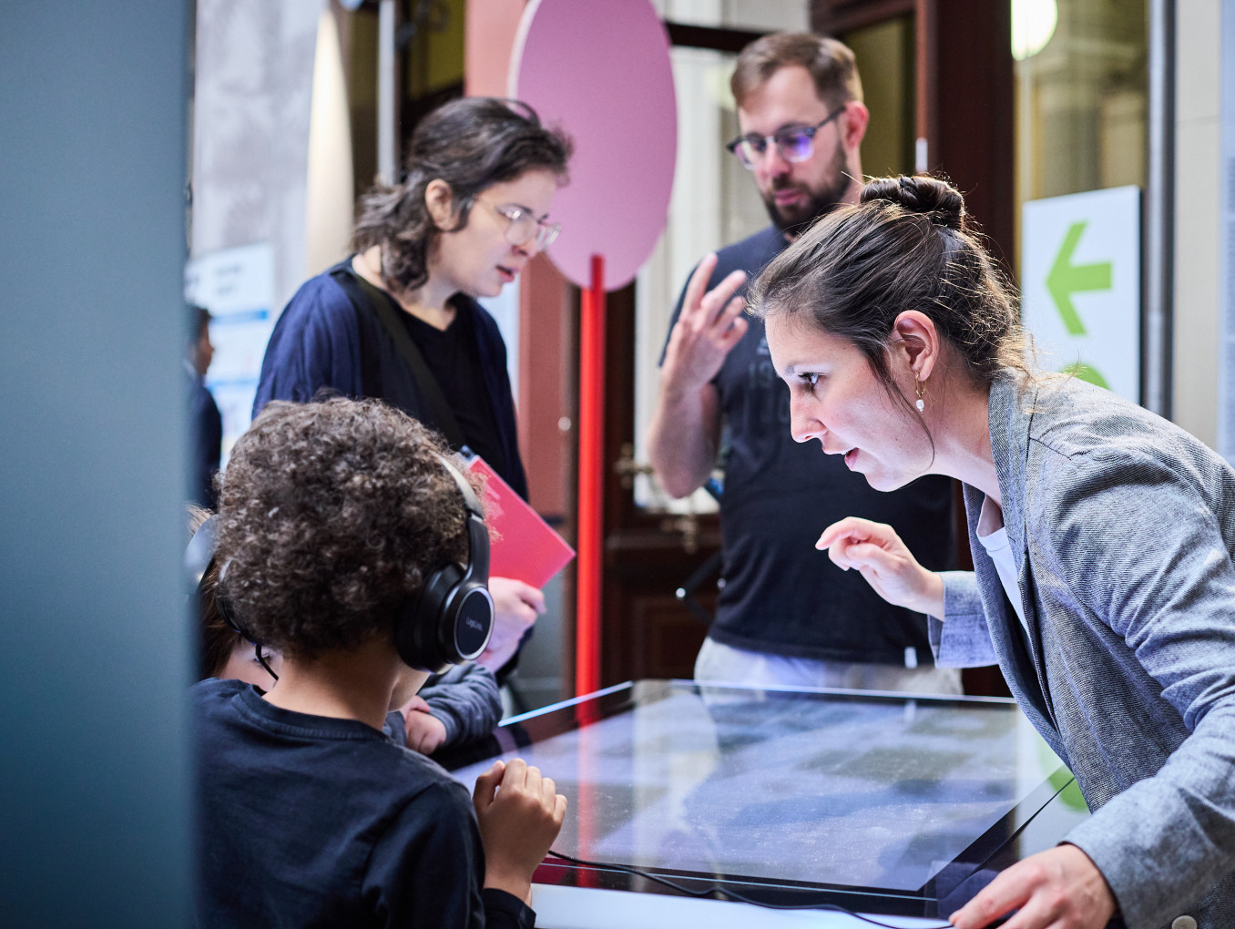A woman stands at a screen with a child 