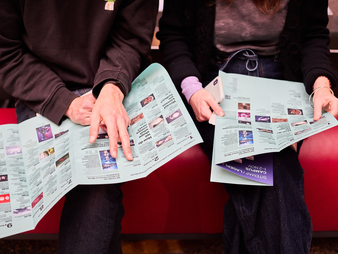Two people hold programme booklets