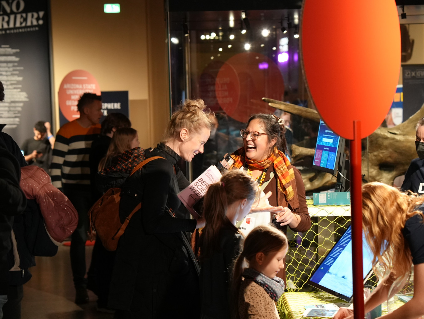 People smiling at one another in a museum. 