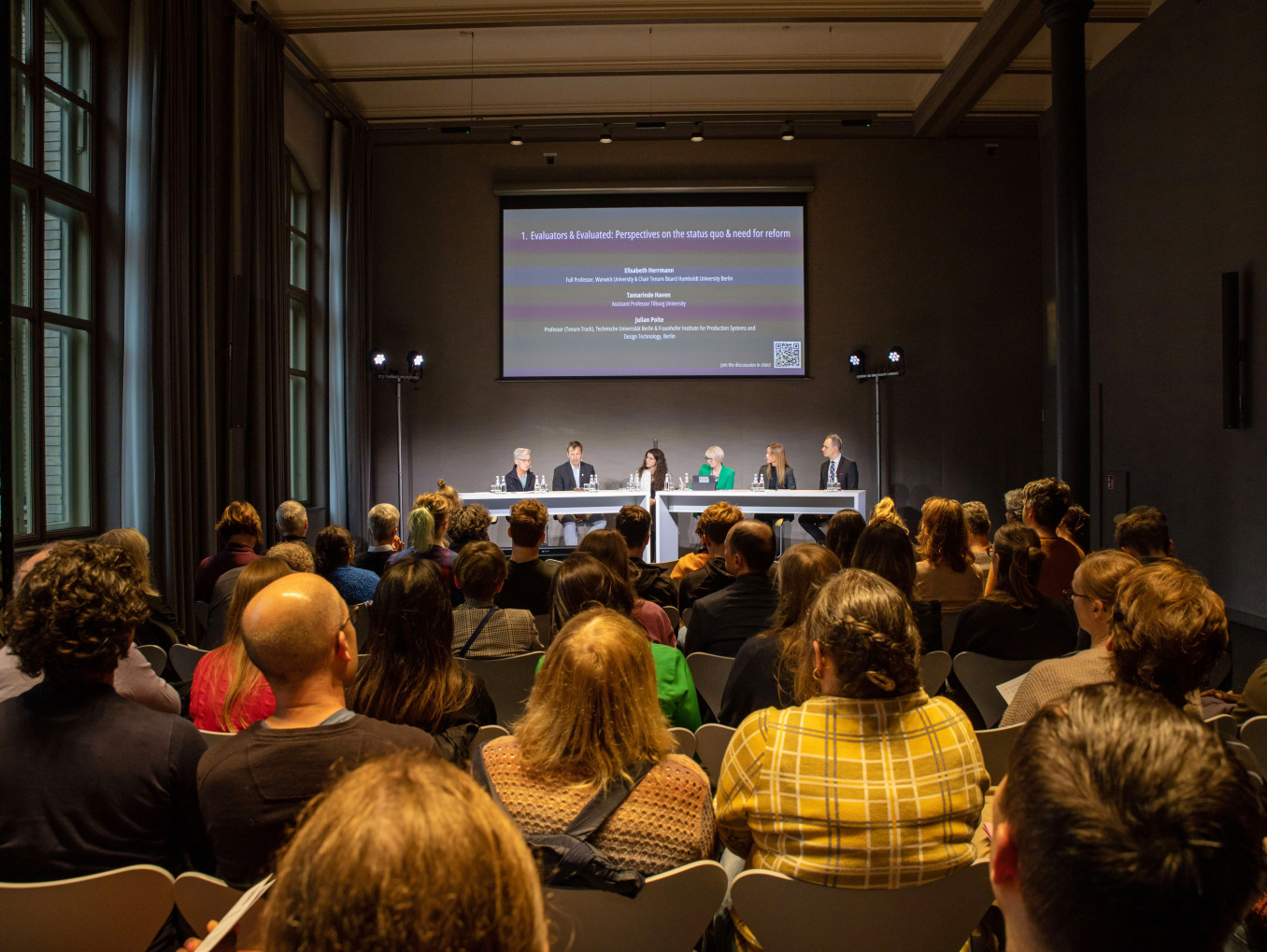 People looking at a panel discussion 