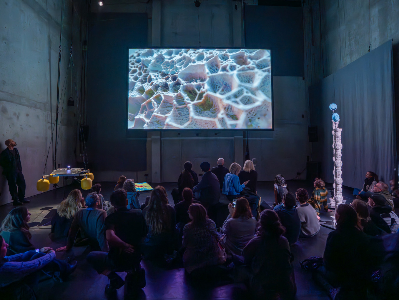 People staring at a huge screen 