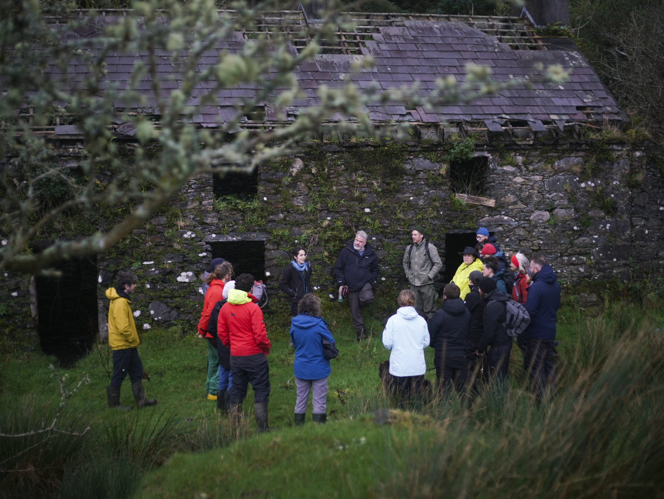 Image of a group standing outside an old stone cottage in the Irish uplands