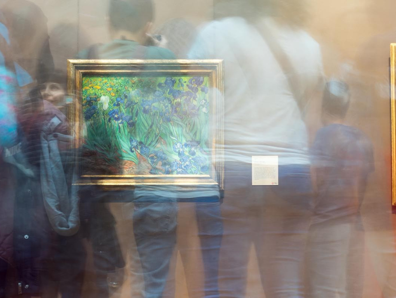 Double-exposure shadows of people in a gallery space with impressionist paintings