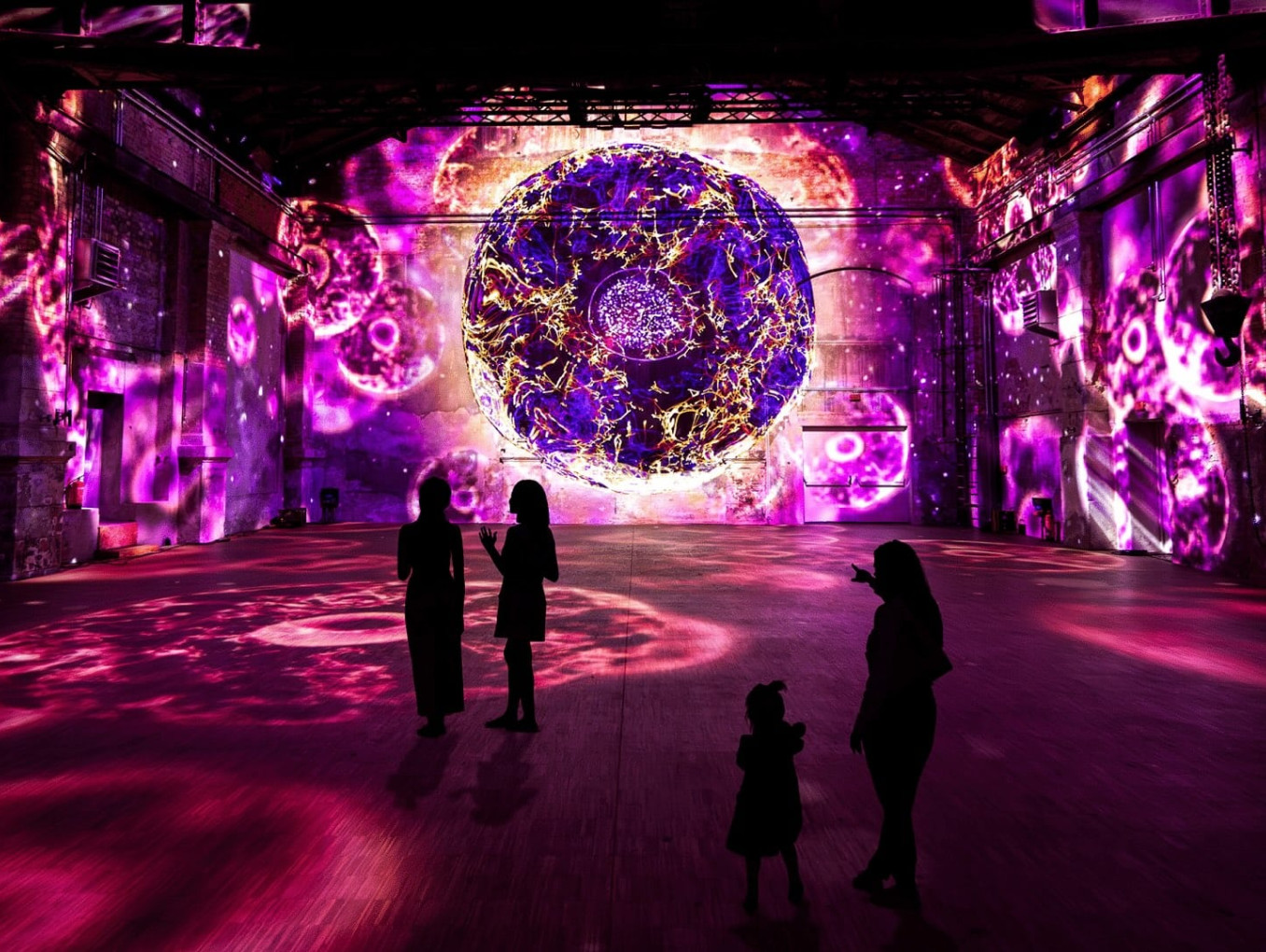 Immersive experience; people standing in a room surrounded by a immersive exhibition 
