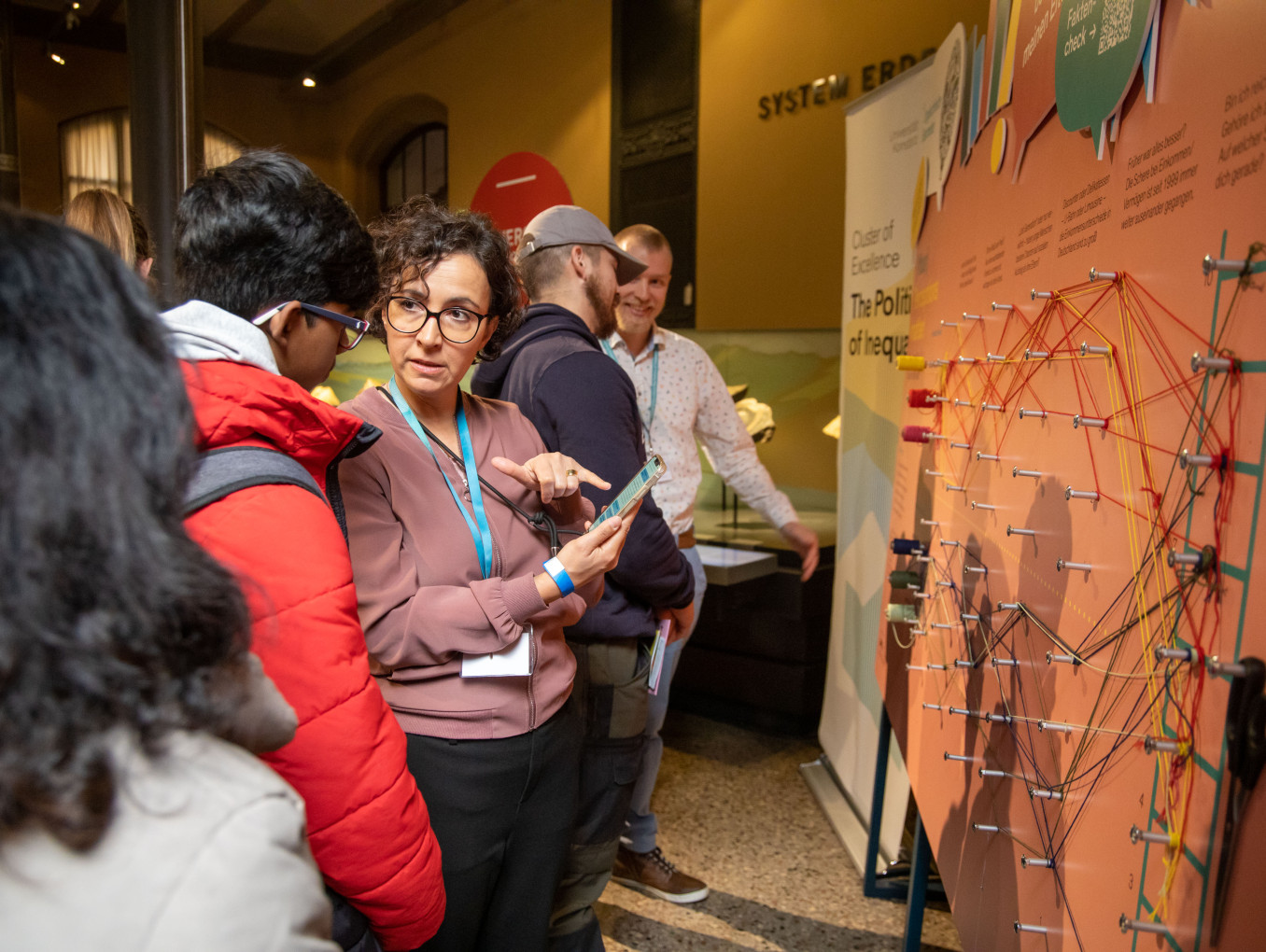 Am Stand des Exzellenzclusters auf der Berlin Science Week 2024 wird Besuchern das Projekt erklärt. 