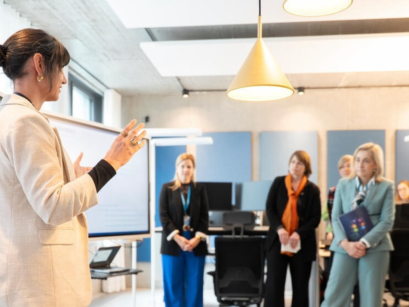 Women presents research to audience in office space.