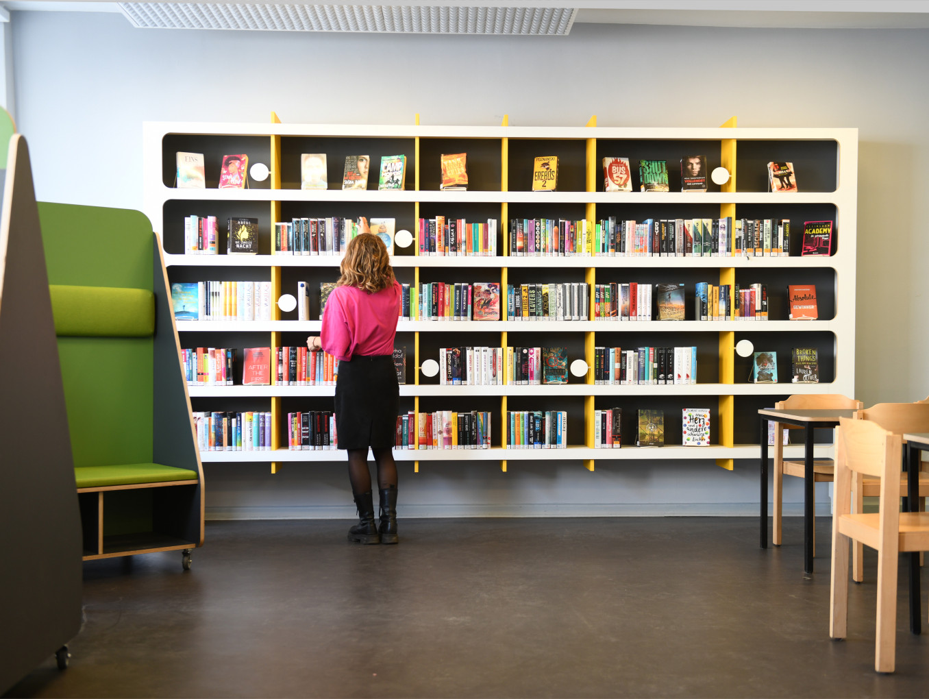 A woman in a library picking a book