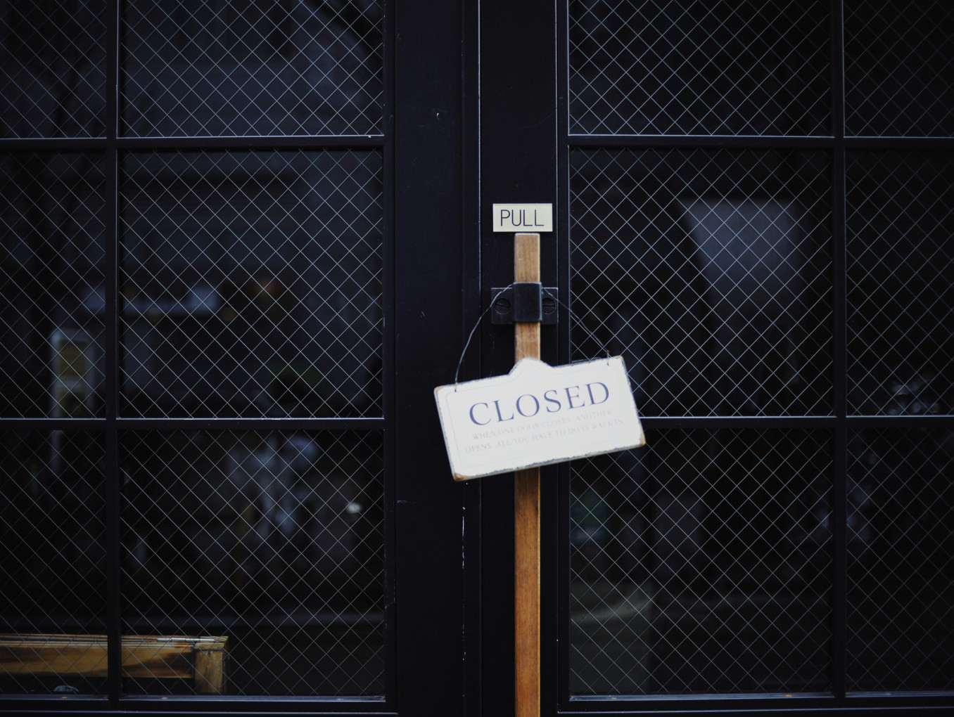 closed black metal door with the sign "closed"
