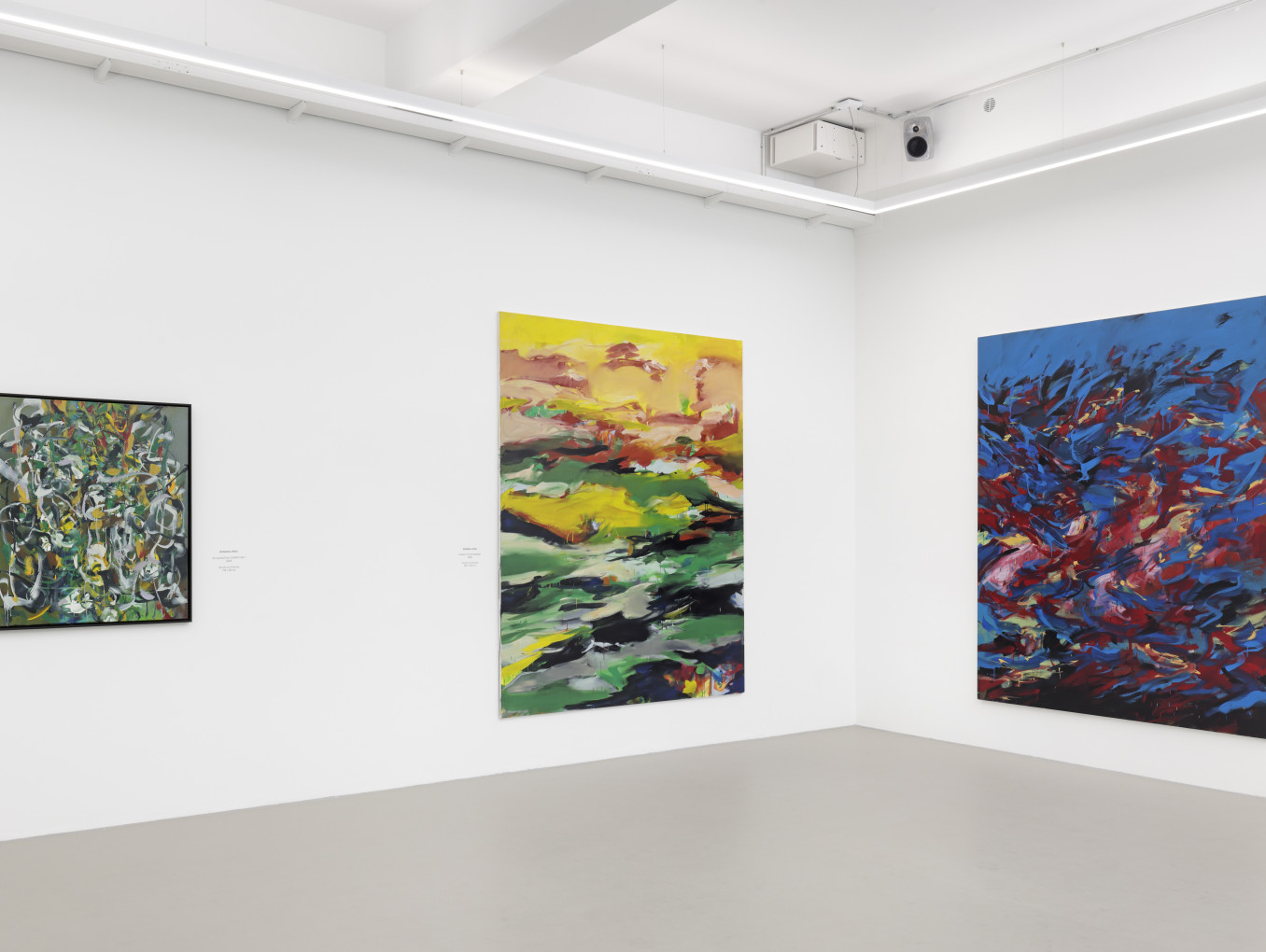 Colourful abstract paintings in gallery.