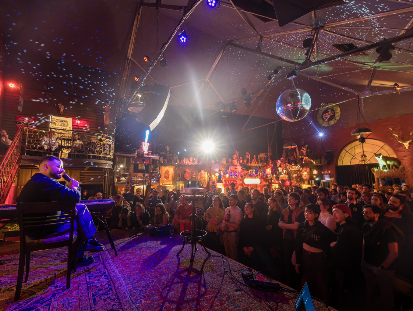 Pub with large audience and man on stage