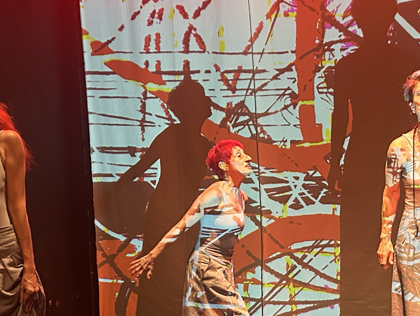 Three performers in front of an abstract video projection