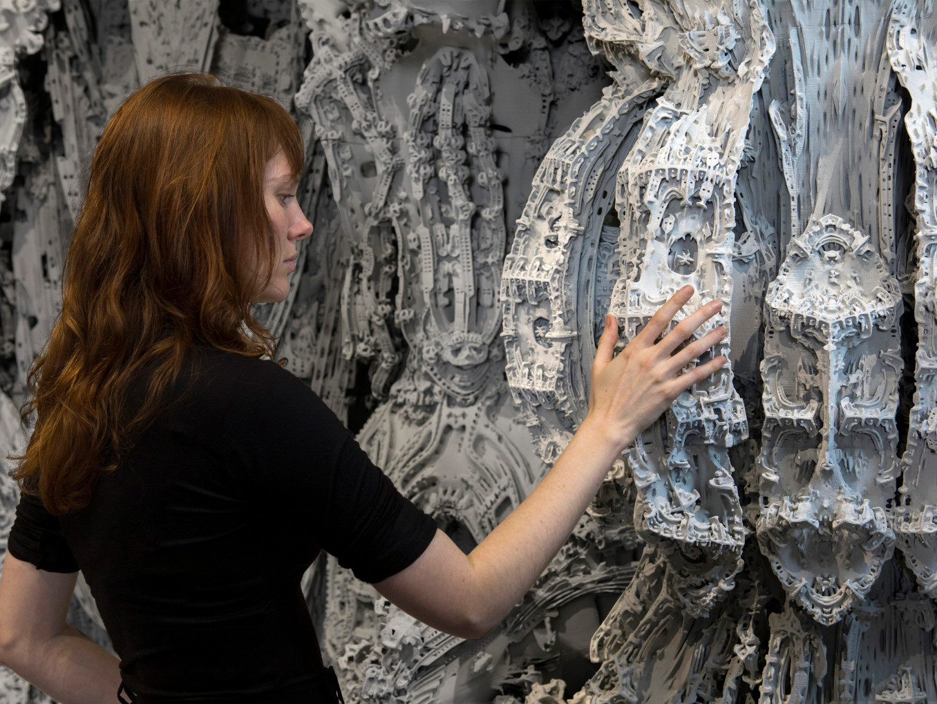 Das Bild zeigt eine Frau vor einem 3D gedrukten Architekur-Objekt.