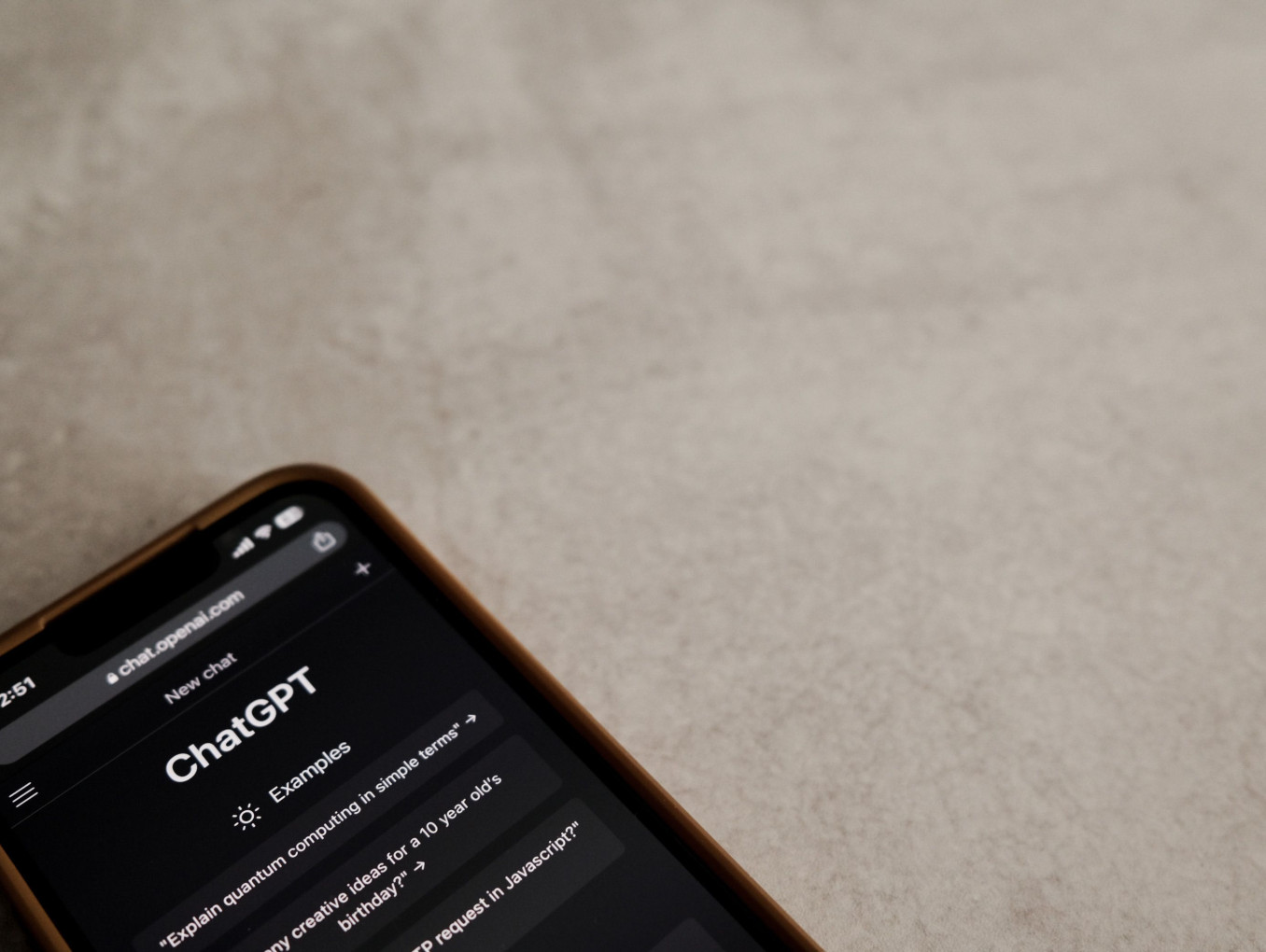 A smartphone displays the ChatGPT interface on its screen.