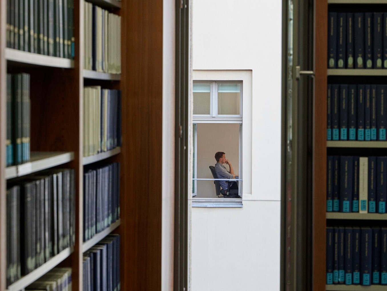 Blick durch ein Fenster auf eine Person