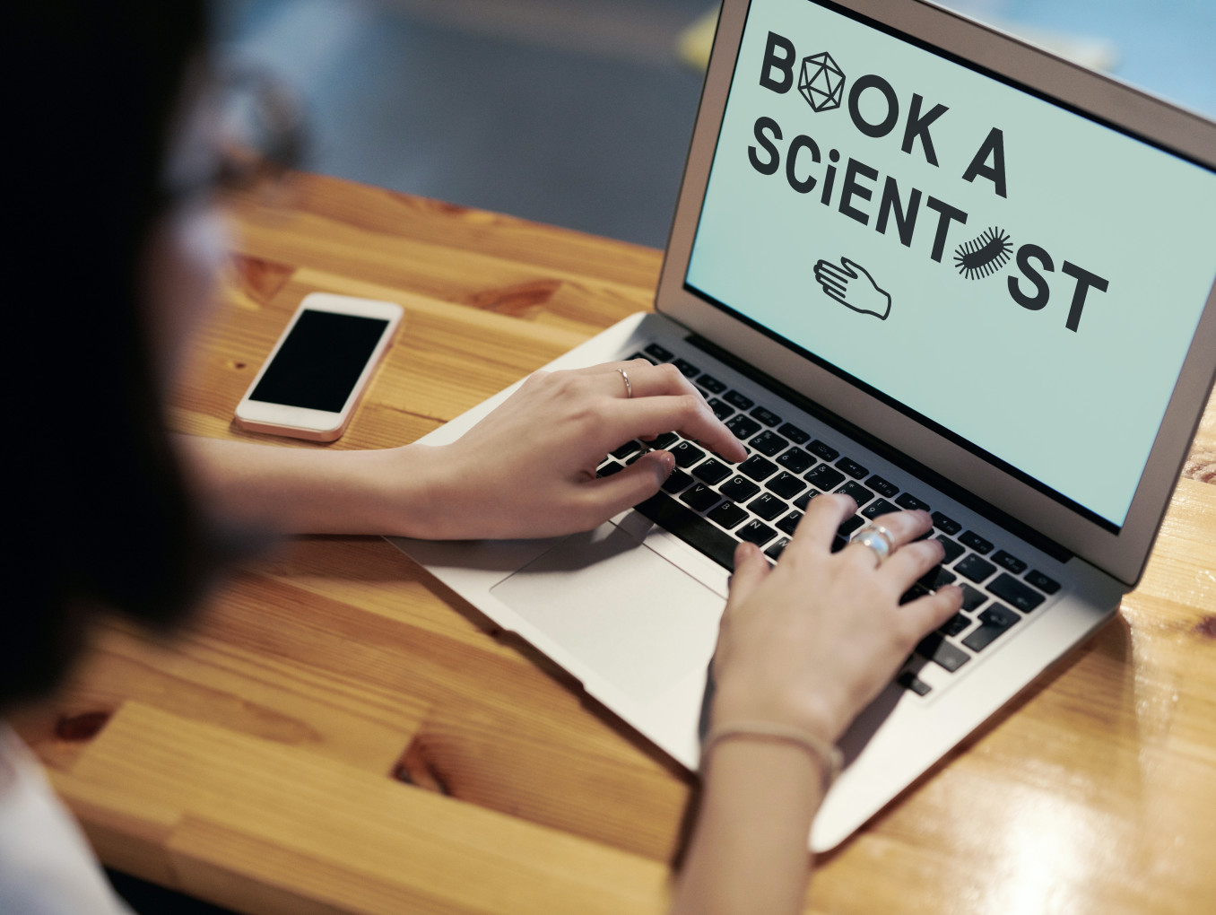 Das Foto zeigt ein Bild eines Laptops mit dem Hinweis auf Book a Scientist