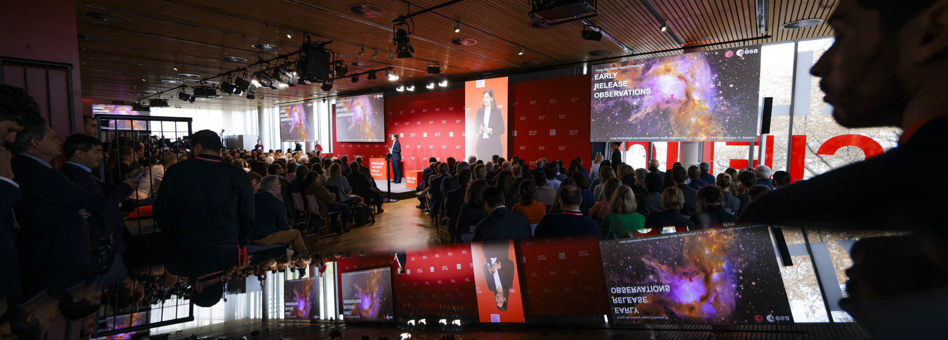 Event room, spotlight on the stage, a lot of people listening
