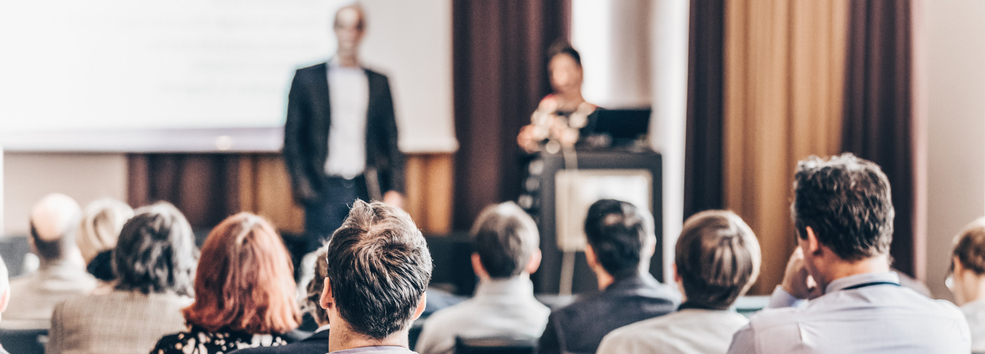 A group of people in a room watching a debate.