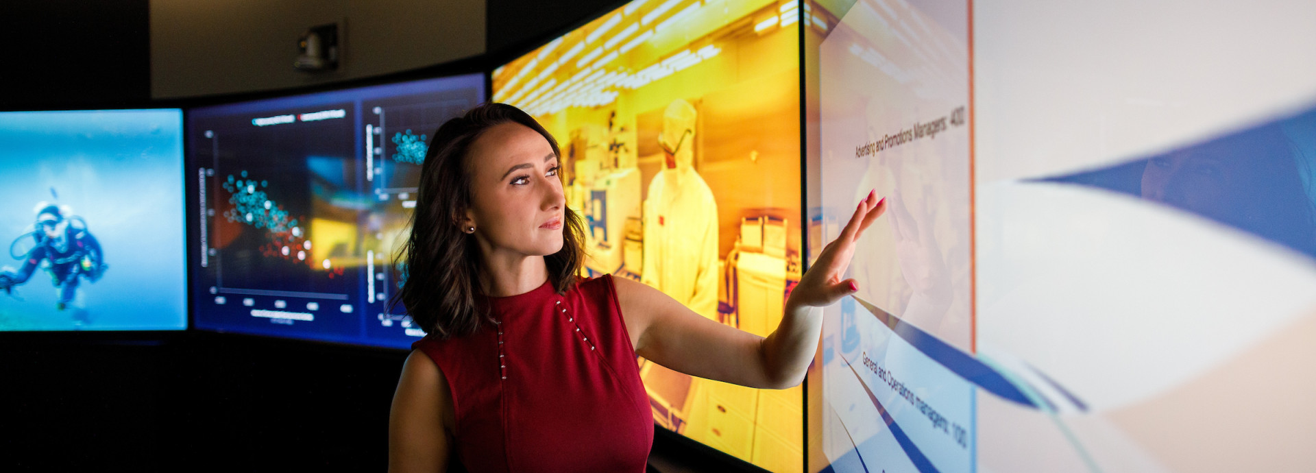 A woman taps a screen of the Decision Theater 
