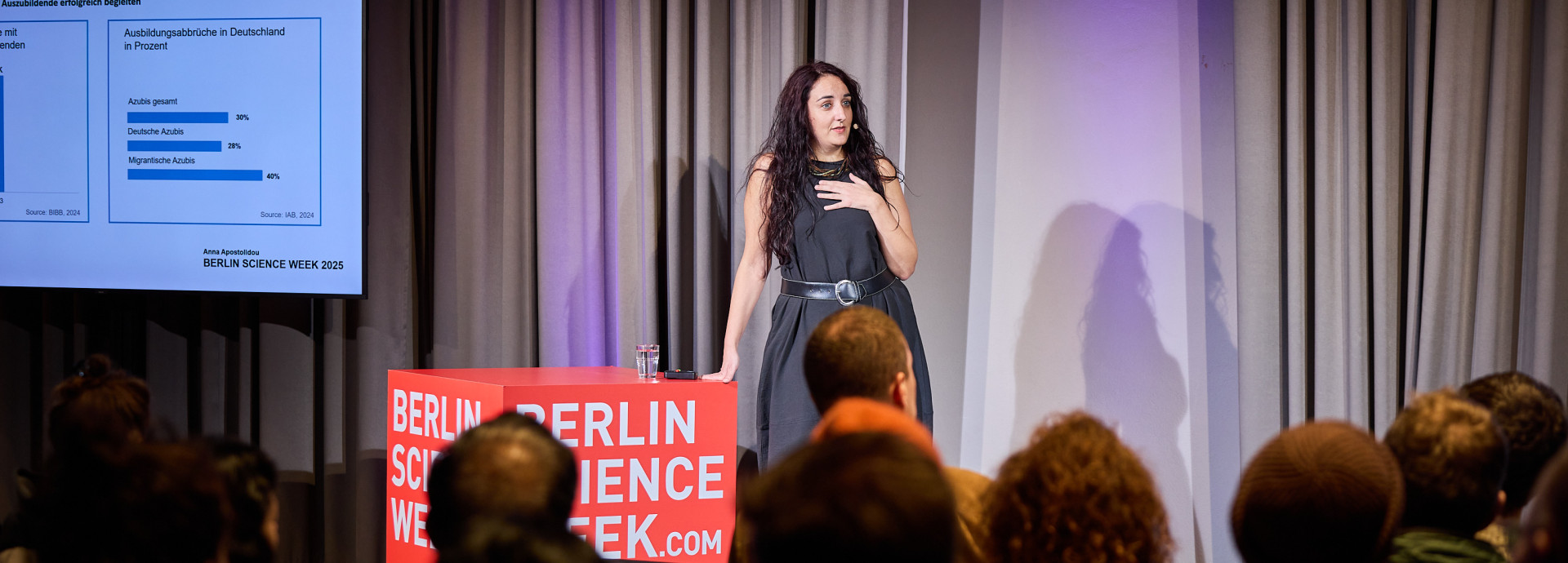 A woman on stage with a cube