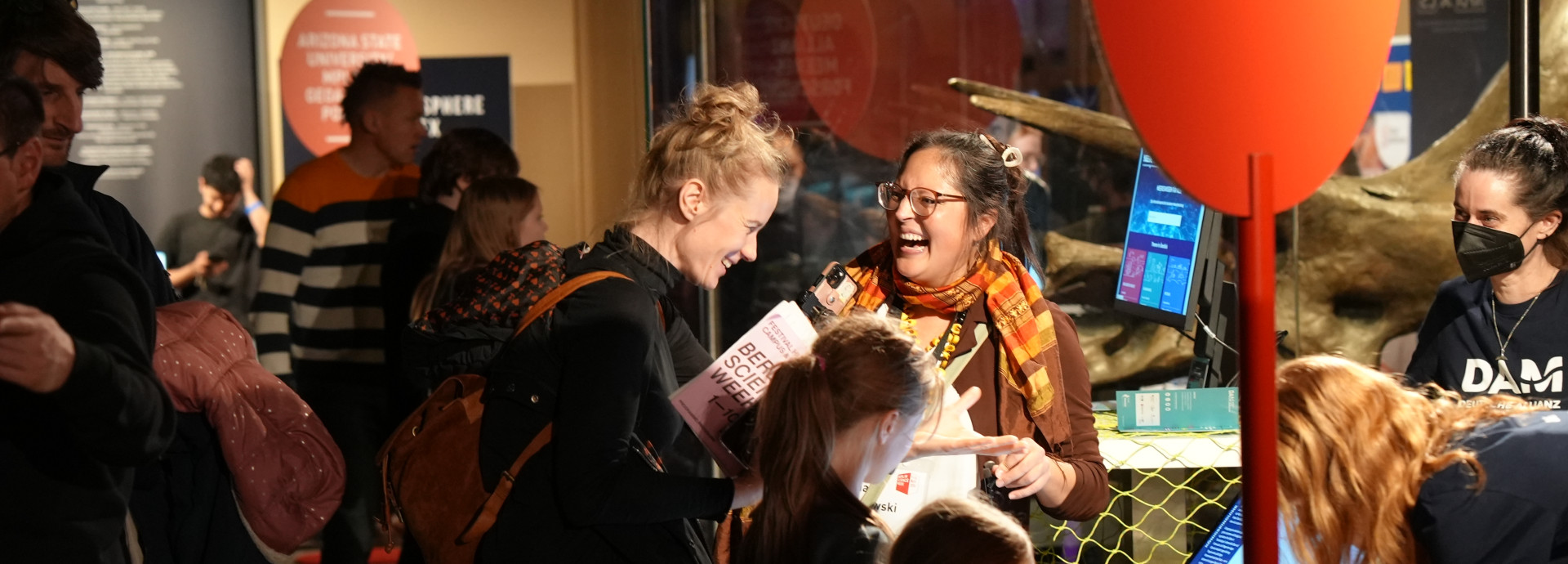 People smiling at one another in a museum. 