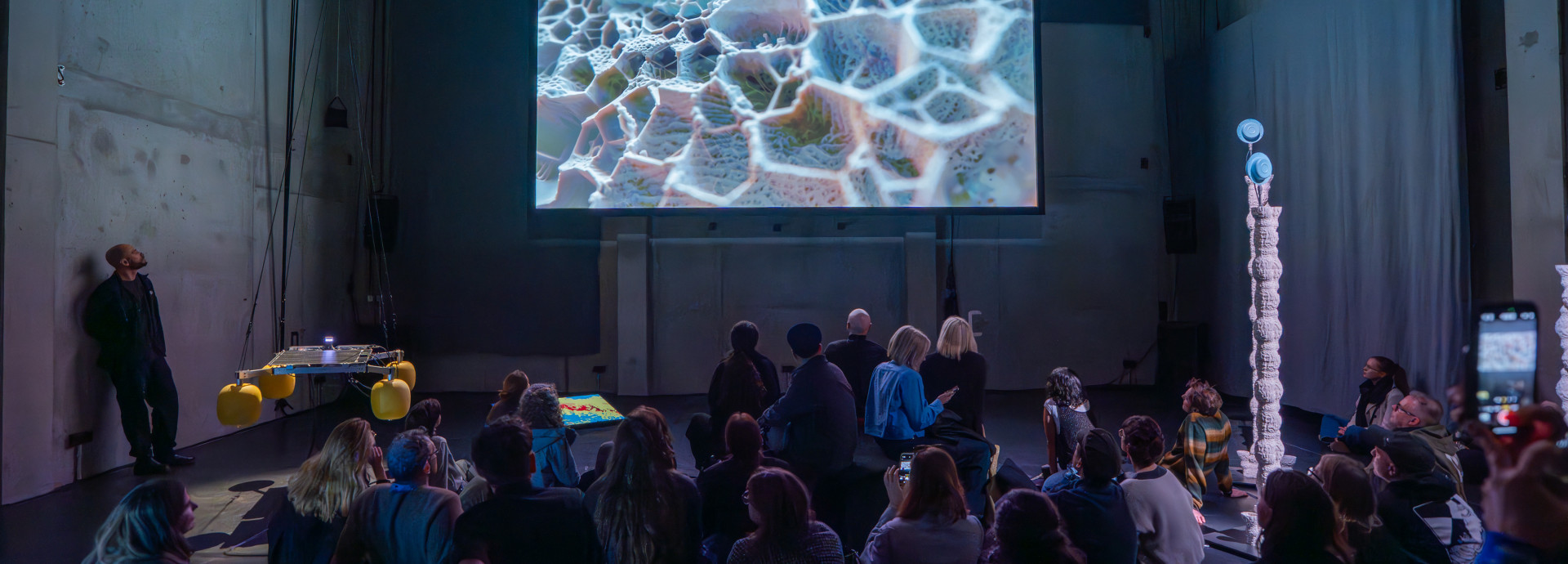 People staring at a huge screen 