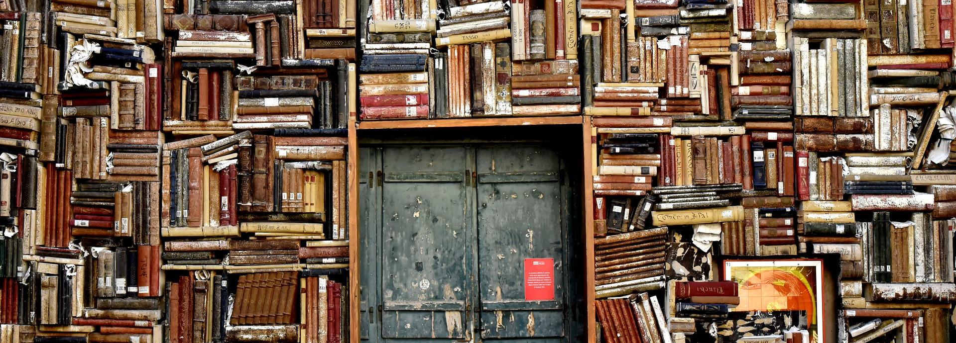 wall with door and bookshelves crammed with books 