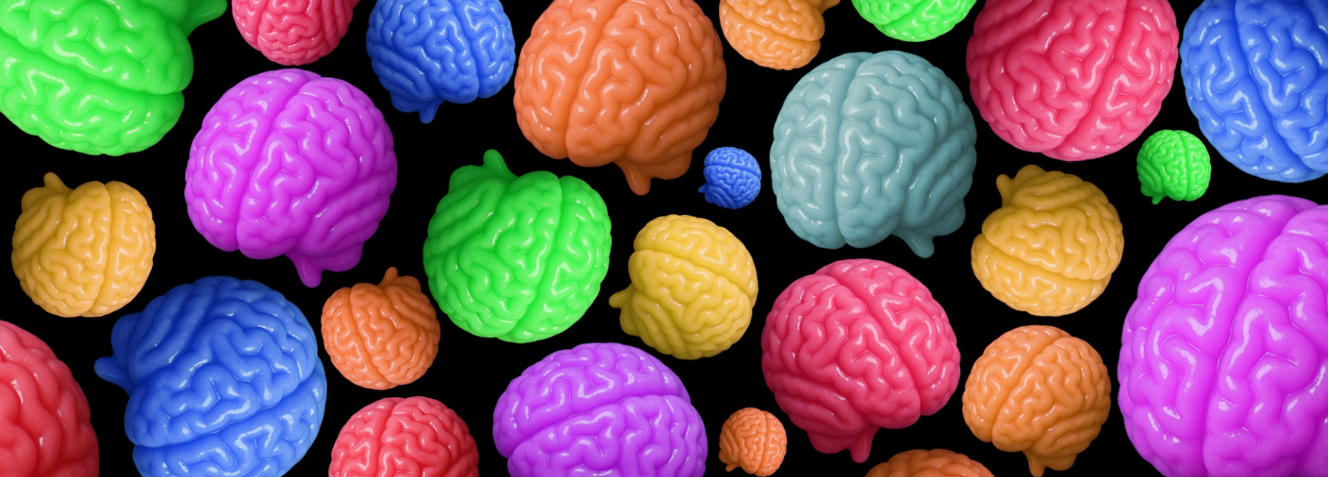 Little gummy brains of different colors and sizes on top of a black background