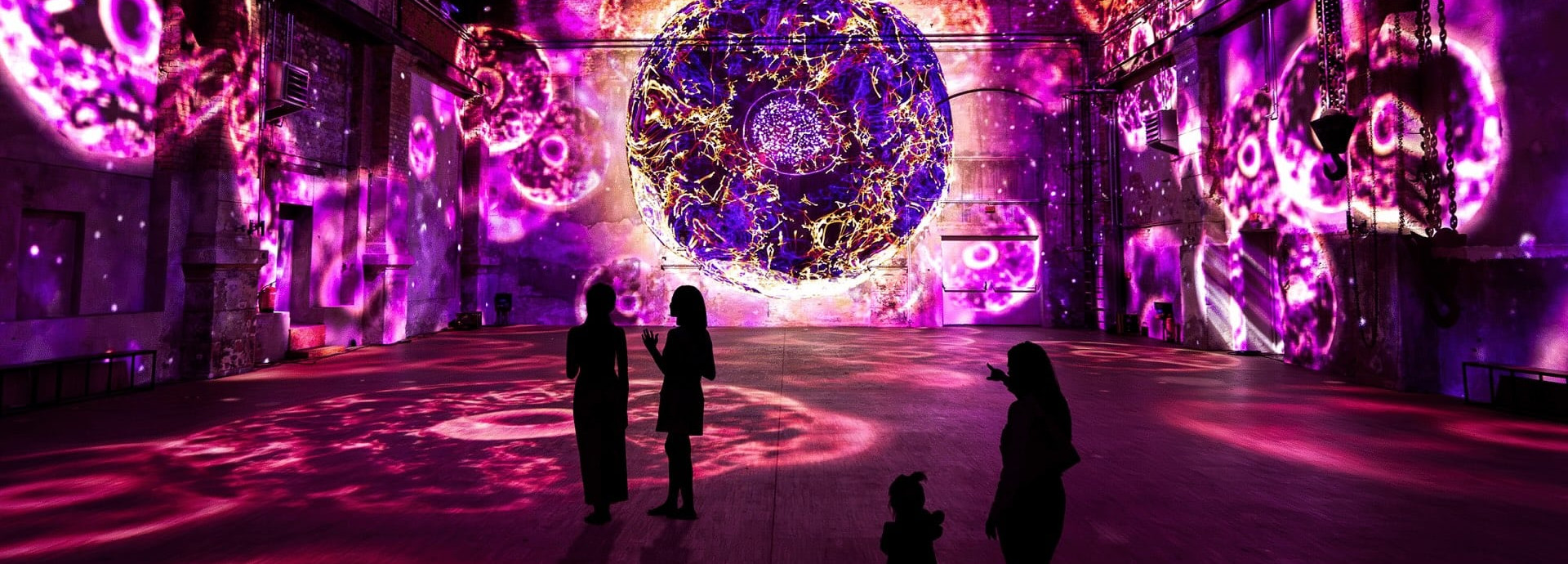 Immersive experience; people standing in a room surrounded by a immersive exhibition 