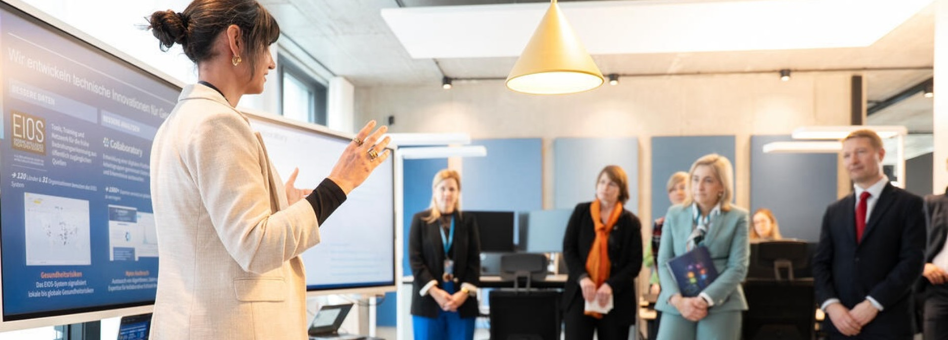 Women presents research to audience in office space.