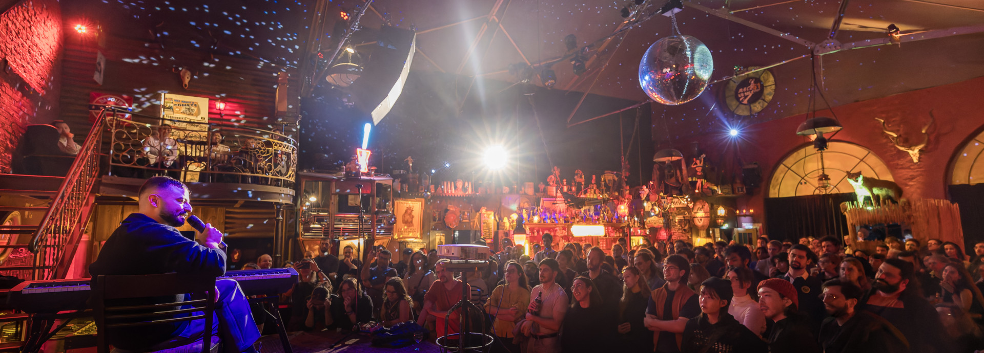 Pub with large audience and man on stage