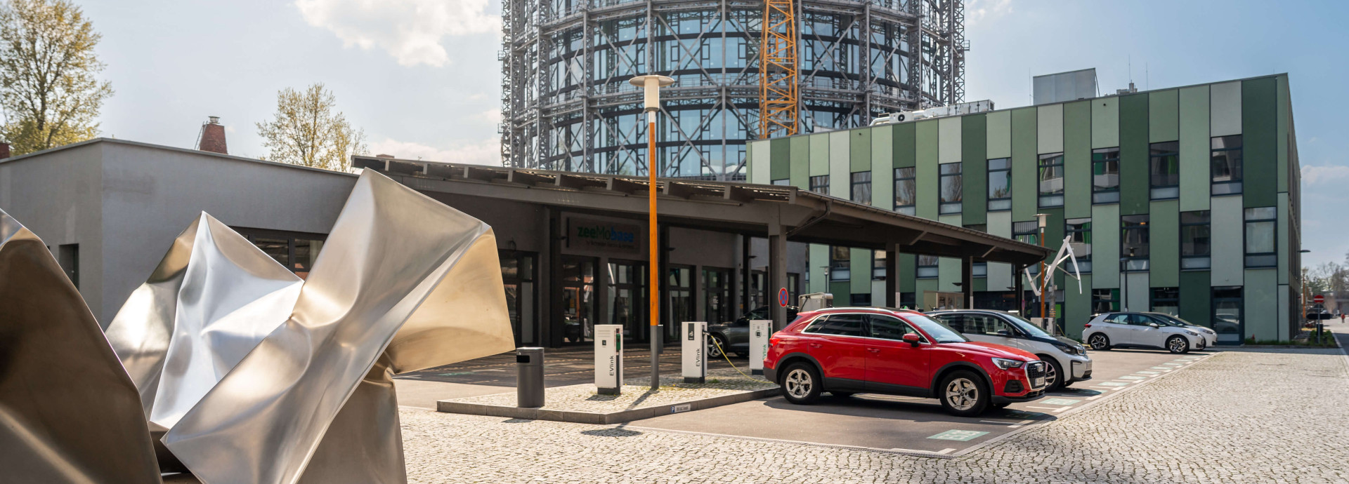 Photo of car park and entrance to zeemobase with abstract statue