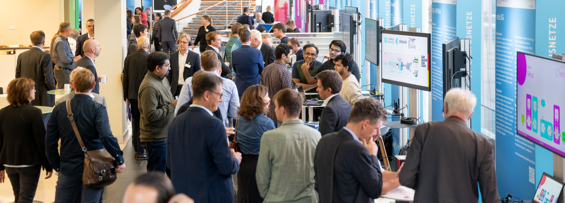 Besucherinnen und Besucher tauschen sich im Ausstellungsbereich der Tage der digitalen Technologien aus.