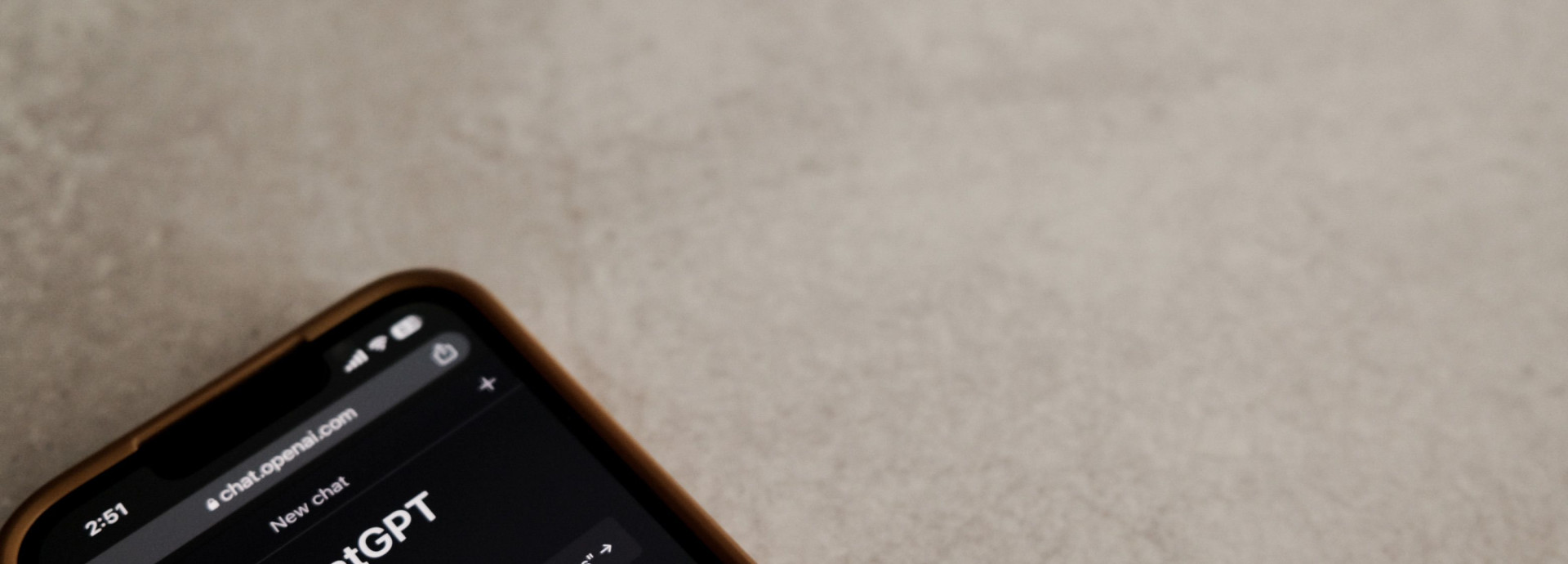 A smartphone displays the ChatGPT interface on its screen.