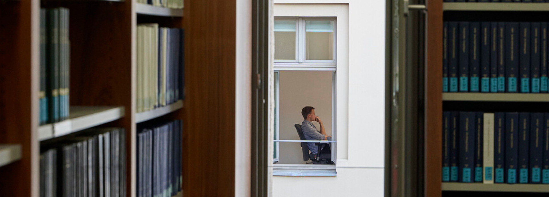 Blick durch ein Fenster auf eine Person