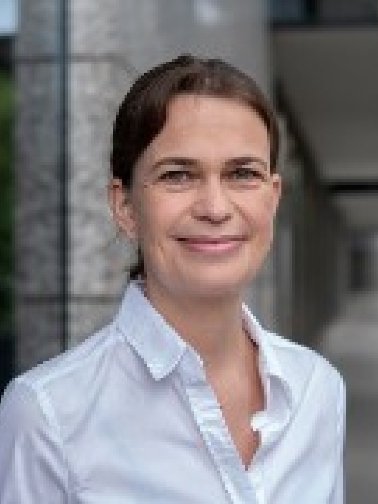 A woman in front of a building with pillars made of concrete