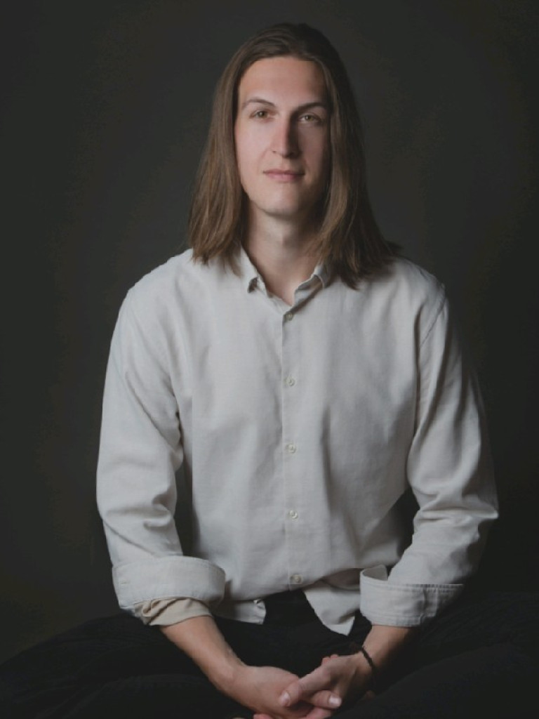 Portrait of lecturer Dr. Marvin Däumichen, sitting on a chair