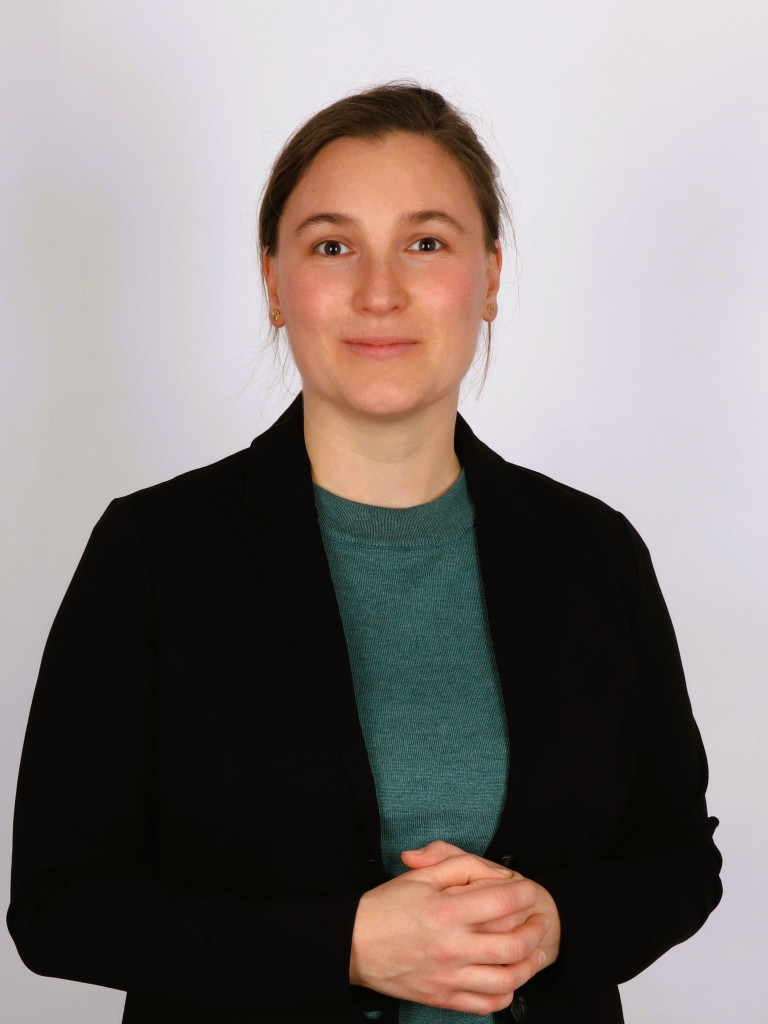 Women with black blazer in front of white background.