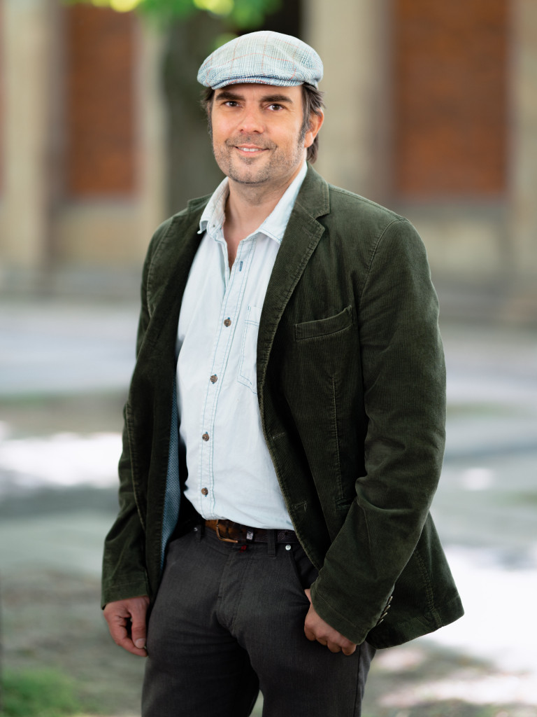 Professor Robischon stands in front of a building