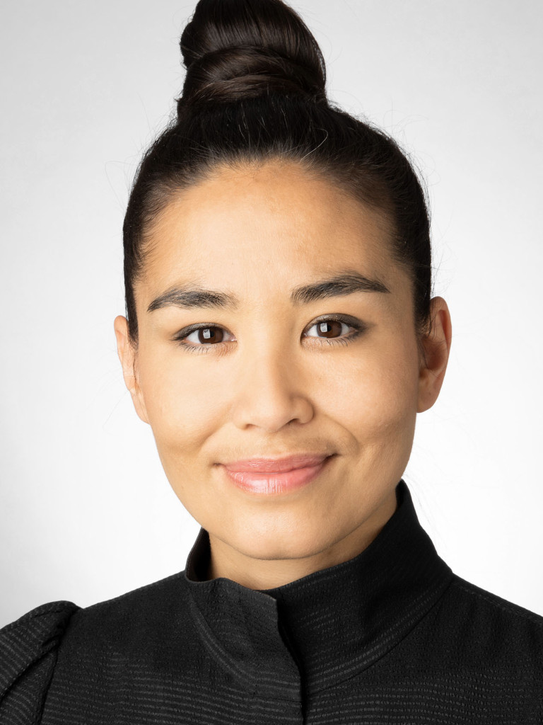 Picture of Kim Mortega (woman with her brown hair in a bun)