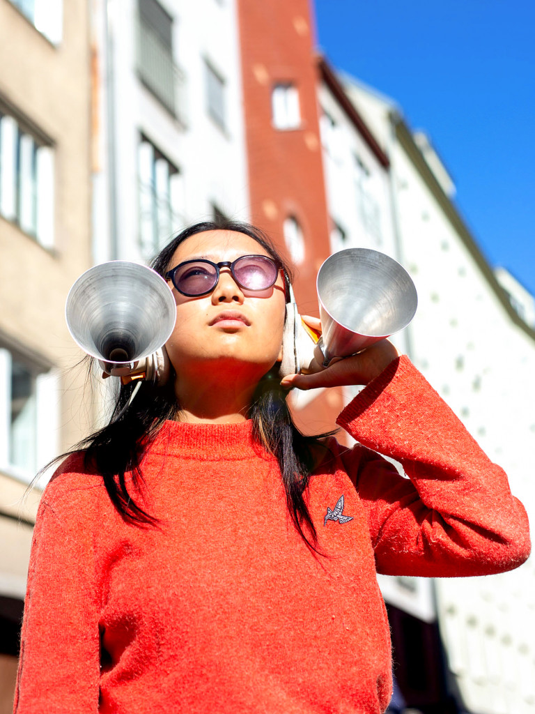 person with an orange pullover wearing a metal headpiece