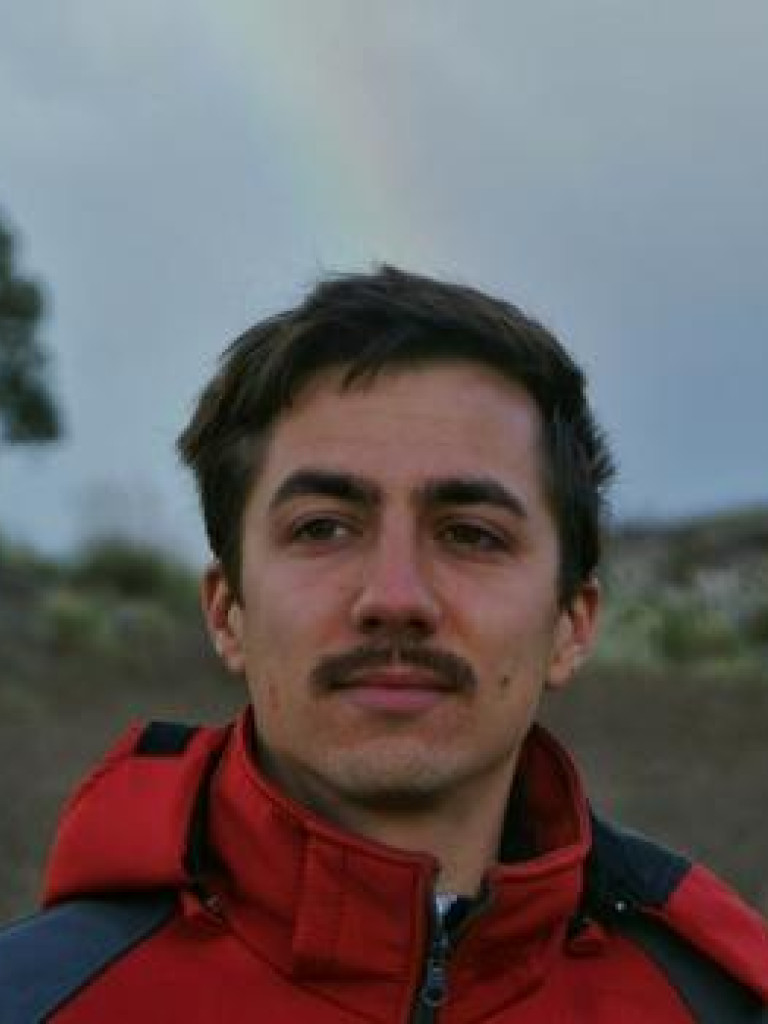 Person looking left of the camera, standing in nature