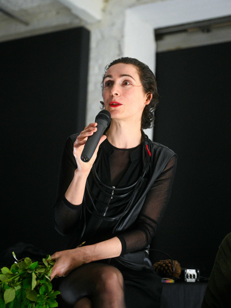 Portrait of the artist, speaking on a podium in mircophone
